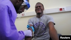 The blood of a survivor of the Ebola virus is extracted as part of a study launched at Liberia's John F. Kennedy Hospital in Monrovia, Liberia, June 17, 2015.