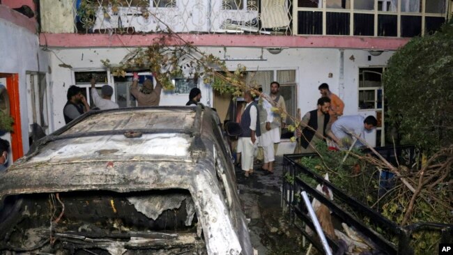 FILE - In this Aug. 29, 2021 file photo, Afghans inspect damage of Ahmadi family house after U.S. drone strike in Kabul, Afghanistan.