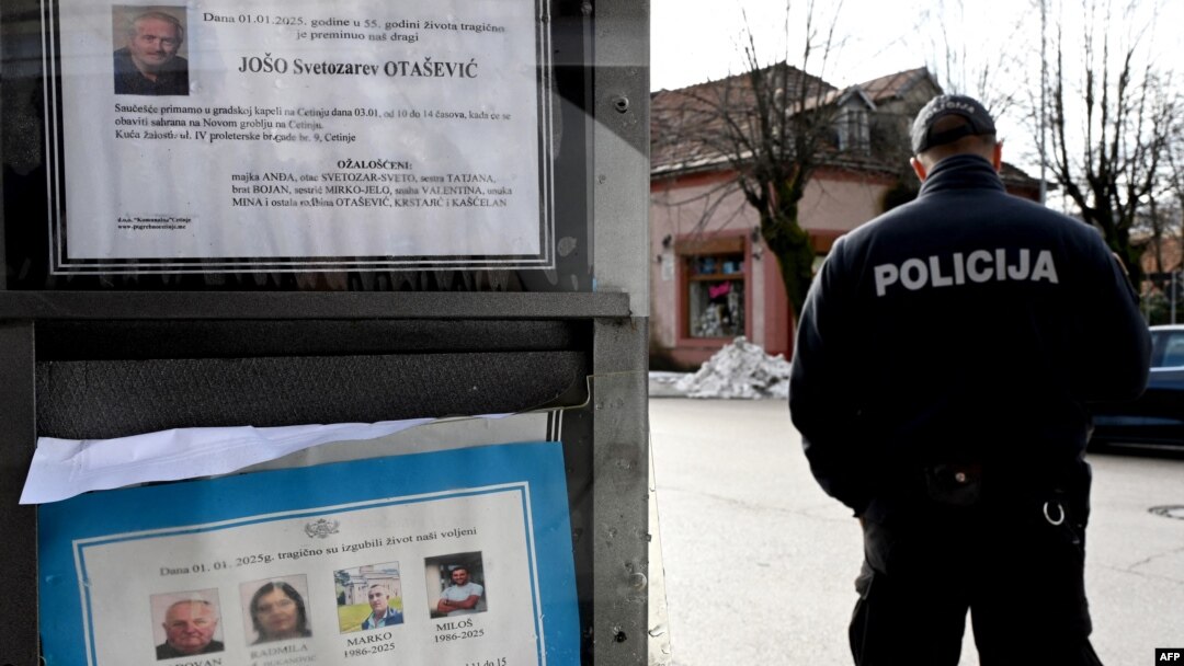 Policajac ispred table na kojoj stoje čitulje na Cetinju (Foto: SAVO PRELEVIC/AFP)