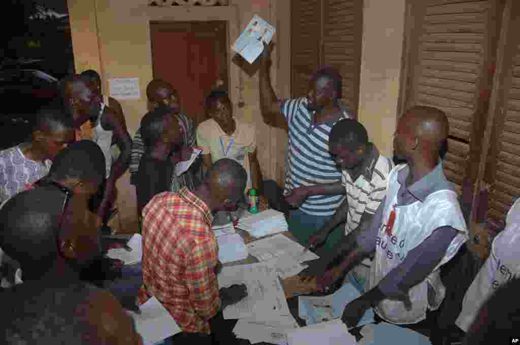 Election workers count legislative ballots after the close of voting, at a polling station in Conakry, Guinea, Sept. 28, 2013. 