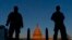 FILE - National Guard members stand their posts around the Capitol at sunrise in Washington, March 8, 2021. 