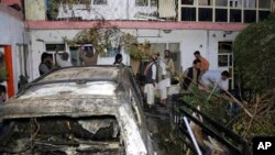 FILE - In this Aug. 29, 2021 file photo, Afghans inspect damage of Ahmadi family house after U.S. drone strike in Kabul, Afghanistan.