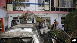 FILE - In this Aug. 29, 2021, photo, Afghans inspect damage to the Ahmadi family house after a U.S. drone strike in Kabul, Afghanistan. The strike killed 10 civilians.