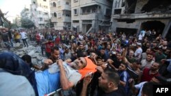 FILE - Palestinians evacuate a wounded man from the site of an Israeli strike on Gaza City on October 10, 2023.