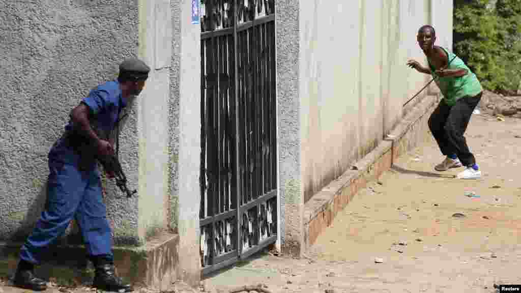 Policemen clash with protesters near a parliament building during a protest against Burundian President Pierre Nkurunziza's decision to run for a third term in Bujumbura, Burundi, May 13, 2015. 