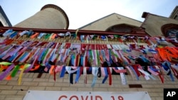 Ribbons hang in remembrance of victims of the coronavirus pandemic outside the Grant African Methodist Episcopal Church, Tuesday, May 19, 2020, in Boston.