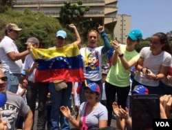 Venezuelan anti-government protesters including activist Lilian Tintori, center right in printed T-shirt, demonstrate in Caracas, April 20, 2017. Tintori’s shirt bears a likeness of her husband, jailed opposition leader Leopoldo Lopez. (A. Algarro/VOA)