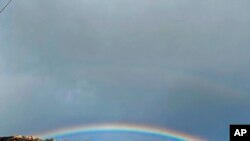 This photo tweeted by the Santa Barbara County Fire Department shows small smoke still smoldering below with a rainbow appearing above the burn scar area near Painted Cave Road in Santa Barbara, California. 