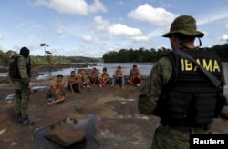 Gold prospectors are detained by agents of Brazil’s environmental agency on the Uraricoera River during an operation against illegal gold mining on indigenous land, in the heart of the Amazon rainforest, in Roraima state, Brazil, April 16, 2016.