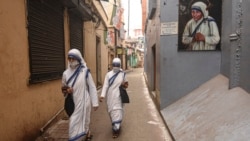 Nuns walk near the entrance of the head office of Missionaries of Charity in Kolkata, Dec. 28, 2021.