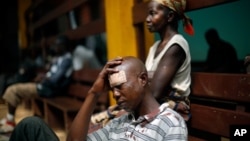A man wounded in fighting between anti-Balaka and ex-Seleka troops sits on the floor in the Community Hospital in Bangui, Central African Republic, Dec. 20, 2013.