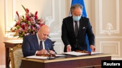 The prosecutor of the International Criminal Court, Karim Khan, signs a cooperation agreement between the ICC and the government of Colombia during his visit to Colombia, in Bogota, Oct. 28, 2021. (Colombian presidency photo)