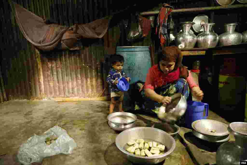 Fifteen-month-old Suhana stands by as her mother Sura Khatum prepares a meal in the family’s kitchen at Kutupalong refugee camp Feb. 15, 2020. (Hai Do/VOA)