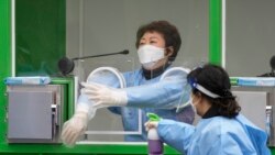 Medical workers wearing protective gear spray disinfectant at a temporary screening clinic for coronavirus in Seoul, South Korea on Dec. 10, 2021.