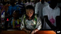 Umat Katolik Kongo mendengarkan Monsinyur Fridolin Ambongo, Uskup Agung Kinshasa yang baru diangkat, memberikan khotbah Natal pada misa tengah malam di Katedral Notre Dame Kongo di Kinshasa, Kongo, Senin, 24 Desember 2018.
