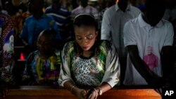 Congolese worshipers listen to Msg. Fridolin Ambongo, the the newly appointed Archibishop of Kinshasa, deliver the homily during an early midnight mass at the Notre Dame du Congo Cathedral in Kinshasa, Congo, Monday Dec. 24, 2018. 