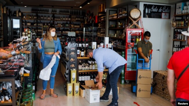 Ainhoa Martinez (L) prepares an order at the Ronda Gourmet shop in downtown Ronda, southern Spain, Sept. 2, 2021.