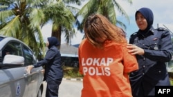 Warga negara Inggris, Samantha Jones (tengah) dikawal polisi di pengadilan di Langkawi, 30 Oktober 2018. (Foto: Alif BAKRI / AFP)
