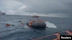 A still image taken from a video shows migrants at sea waiting to be rescued by Spanish search and rescue ship Open Arms during an operation in the Mediterranean Sea, Nov. 11, 2020.