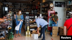 Ainhoa Martinez (L) prepares an order at the Ronda Gourmet shop in downtown Ronda, southern Spain, Sept. 2, 2021. 