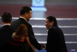 FILE - China's President Xi Jinping, left, shakes hands with Philippines President Rodrigo Duterte during the opening ceremony of the 2019 Basketball World Cup in Beijing, China, Aug. 30, 2019.