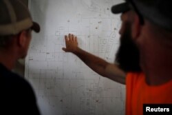 50 Star Search and Rescue team members Robert Pepper, left, and John Basehore study a map of the search area following Hurricane Michael in Youngstown, Florida, Oct. 17, 2018.
