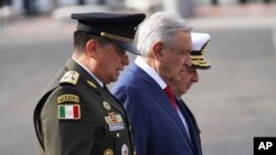 ARCHIVO - El presidente Andrés Manuel López Obrador camina entre el secretario de Defensa, Luis Crescencio Sandoval, en primer plano, y el secretario de la Armada Vidal Francisco Soberón, en septiembre de 2022.