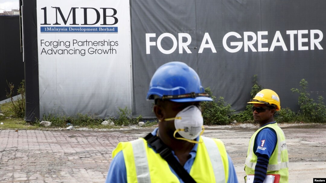 Para pekerja bangunan di depan papan iklan 1Malaysia Development Berhad (1MDB) di proyek pembangunan Tun Razak Exchange di Kuala Lumpur, Malaysia, 3 Februari 2016. (Foto: Reuters)