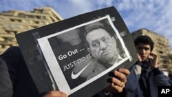 A protester holds a placard showing Egyptian President Hosni Mubarak and reading "Go out... Just do it" at the continuing anti-government demonstration in Tahrir Square in downtown Cairo, Feb 10 2011