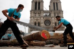 Carpenters showcase medieval techniques in front of Notre Dame Cathedral in Paris, France, Sept. 19, 2020. A total of 25 trusses are to be installed at an unknown date in the cathedral nave.
