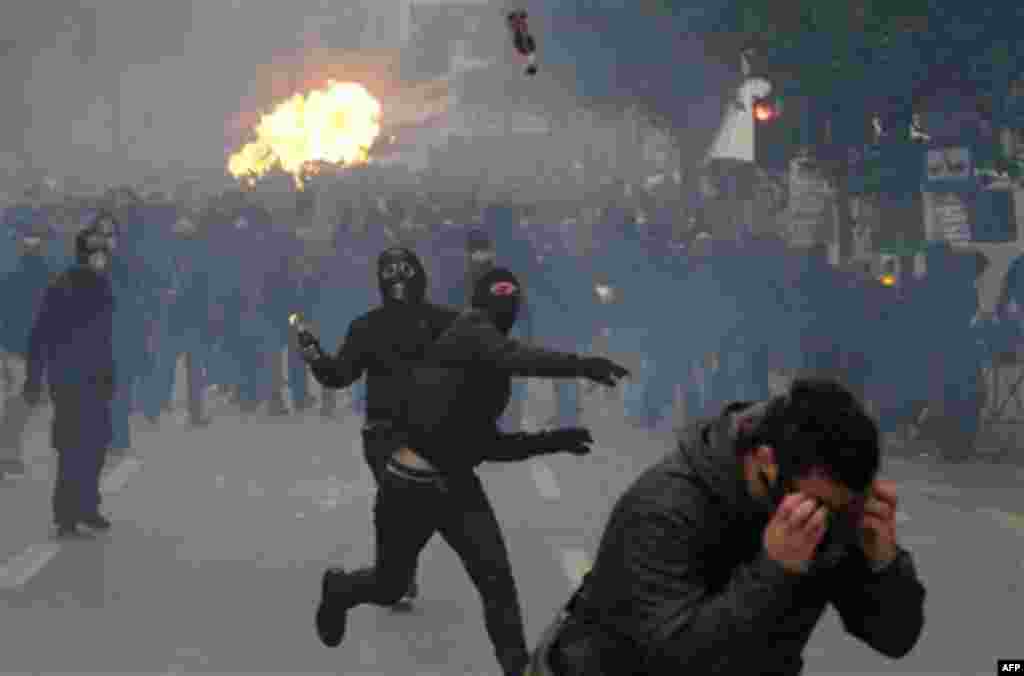 Protesters throw petrol bombs during clashes in Athens, Wednesday, Dec. 15, 2010. Hundreds of protesters clashed with riot police across central Athens Wednesday, smashing cars and hurling gasoline bombs during a massive labor protest against the governme