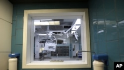 FILE - An operating room is seen through a window at a sanitizing station in New Orleans.
