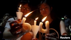 Pro-democracy supporters hold candles in the shape of "64", which symbolizes "June 4th", during an annual candlelight vigil at Victoria Park in Hong Kong, China, June 4, 2015 to mark Beijing's Tiananmen Square crackdown in 1989.