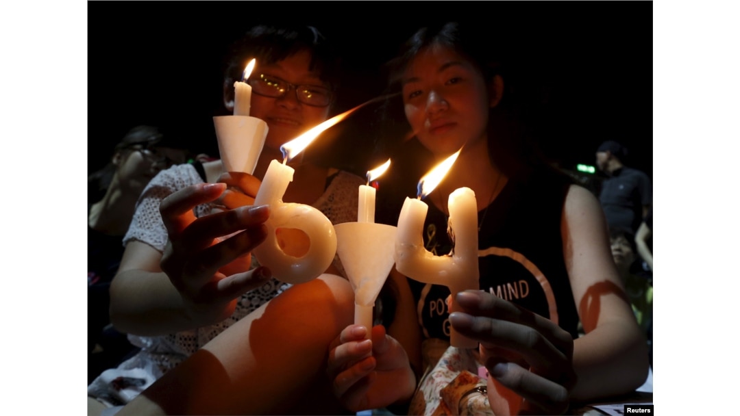 FILE - Pro-democracy supporters hold candles in the shape of "64", which symbolizes "June 4th", during an annual candlelight vigil at Victoria Park in Hong Kong, China, June 4, 2015 to mark Beijing's Tiananmen Square crackdown in 1989.