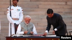 بھارتی وزیر اعظم نریندر مودی حلف برداری کے بعد دستاویزات پر دستخط کر رہے ہیں۔ 30 مئی 2019