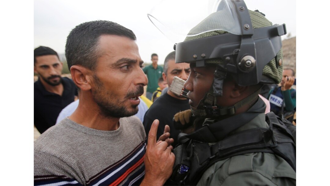 A Palestinian demonstrator argues with an Israeli border policeman during a protest against Jewish settlements near Hebron, in the Israeli-occupied West Bank, Nov. 15, 2019.
