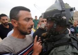 A Palestinian demonstrator argues with an Israeli border policeman during a protest against Jewish settlements near Hebron, in the Israeli-occupied West Bank, Nov. 15, 2019.