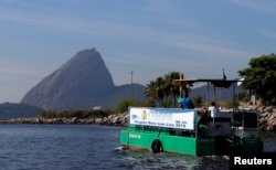 A garbage-collecting boat in seen in front of the Sugar Loaf mountain at the Guanabara Bay in Rio de Janeiro, March 12, 2014.