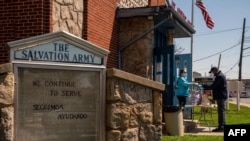 Salvation Army workers distribute free meals, April 15, 2020, in Staten Island, New York City. Gov. Andrew Cuomo said he would invoke an executive order requiring citizens to wear masks in public when social distancing is not possible.