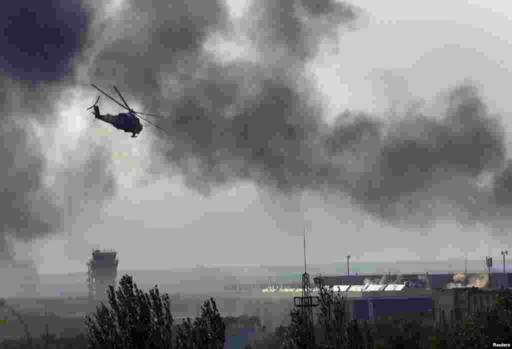 Um helicóptero ucraniano Mi-24 dispara contra rebeldes no edifício do principal aeroporto em Donetsk, Ucrânia, Maio 26, 2014.