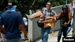 Un hombre carga a un manifestante herido en la localidad de San Cristóbal. En otro hecho, Francisco Rosendo Marín se suma a la lista de fallecidos en Venezuela. 