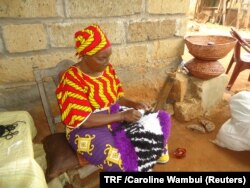 FILE - Regina Kaari weaves a mat in Mathiga Village, Kenya, May 2, 2018.