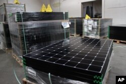 FILE - SunPower solar panels are stacked in Positive Energy Solar's warehouse in Albuquerque, N.M., March 9, 2016.