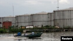 FILE - A boat travels down a river near the southeastern oil city of Warri, in Delta state, Nigeria, June 18, 2017.