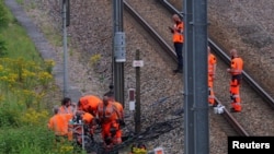 Sejumlah pekerja perusahaan kereta api SNCF dan penegak hukum menyelidiki lokasi sabotase yang menarget kereta cepat Prancis dalam serangan terkoordinasi yang menimbulkan kekacauan besar di pembukaan Olimpiade Paris 2024, 26 Juli 2024. (Foto: Brian Snyder/Reuters)