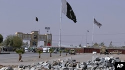 FILE - Pakistan and Taliban flags are seen on their respective sides near Friendship gate at a border crossing point between Pakistan and Afghanistan, in Chaman, Pakistan, Aug. 27, 2021. 