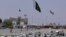 FILE - Pakistan and Taliban flags are seen on their respective sides near Friendship gate at a border crossing point between Pakistan and Afghanistan, in Chaman, Pakistan, Aug. 27, 2021. 