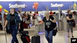 Pasajeros usando mascarillas caminan por el aeropuerto de Tampa, Florida. Aerolíneas como United, American, Delta y otras están exigiendo ahora usar mascarillas.