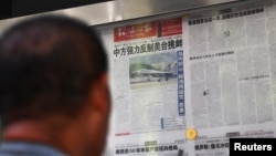 资料照片：一名男子在北京一报刊亭阅读《环球时报》关于中国人民解放军东部战区在台湾附近举行军事演习的报道。(2022年8月5日)