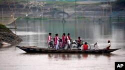 School children ride on a boat with their bicycles to cross the river Brahmaputra in Kasoshila village on the outskirts of Gauhati, India, Monday, Oct. 21, 2019. 